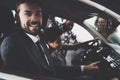 African american family at car dealership. Salesman is showing new car to boy. Royalty Free Stock Photo