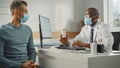 African American Family Doctor is Talking with Young Male Patient During Consultation in a Health Royalty Free Stock Photo