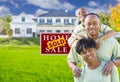 African American Family In Front of Sold Sign and House Royalty Free Stock Photo