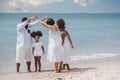 African American family. Happy family Mother, Father, Two daughters walking and playing together on the beach on holiday, having