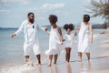 African American family. Happy family Mother, Father, Two daughters walking and playing together on the beach on holiday, having Royalty Free Stock Photo