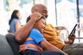 African American Family At Home With Father And Son Sitting On Sofa At Home Using Digital Tablet Royalty Free Stock Photo