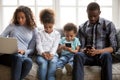 African american family with kids using devices at home