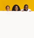 African american family leaning on blank white adverticement board