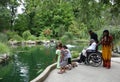 African-American family looking at goldfish in the pond.