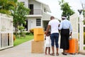 African American family is moving in to a new house with father holding baby with suitcase and baggage for housing and relocation