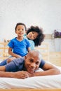 African American family of three, kids sitting on father`s back Royalty Free Stock Photo