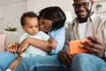 African american family using cellphone with baby at home Royalty Free Stock Photo