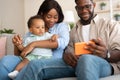 African American family using cellphone with baby at home Royalty Free Stock Photo