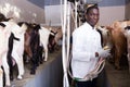 African american farmer milking a goats with an automatic milk machine