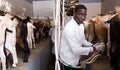 African american farmer milking a goats with an automatic milk machine