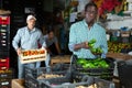 African american farmer sorting harvested peppers and packing into boxes