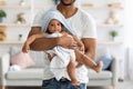 African american father carrying his infant baby in towel after bathing Royalty Free Stock Photo