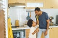 African American Father with Cute son holding kitchen appliance microphones singing while cooking