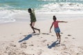 African american father and daughter enjoying while running with arms outstretched at beach Royalty Free Stock Photo