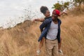 African american father and daughter having fun playing piggyback together during traveling countryside Royalty Free Stock Photo