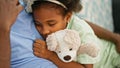 African american father and daughter lying on sofa hugging teddy bear sleeping at home Royalty Free Stock Photo