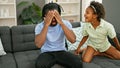 African american father and daughter sitting on sofa stressed for disturb at home