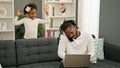 African american father and daughter sitting on sofa working while child disturb at home