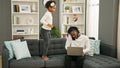 African american father and daughter sitting on sofa working while child disturb at home