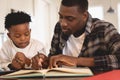 African American father helping his son with homework at table Royalty Free Stock Photo