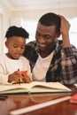 African American father helping his son with homework at table Royalty Free Stock Photo