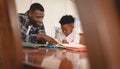 African American father helping his son with homework at table Royalty Free Stock Photo