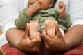 African American father holding his daughters feet.