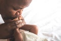African American father kissing foot, his baby newborn Royalty Free Stock Photo