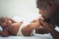 African American father kissing foot of his baby newborn daughter Royalty Free Stock Photo