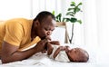 African American father kissing foot, his 12-day-old baby newborn Royalty Free Stock Photo