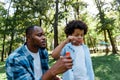 African american father looking at adorable son blowing soap bubble Royalty Free Stock Photo