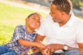 African American Father and Mixed Race Son Playing with Baseball in the Park Royalty Free Stock Photo
