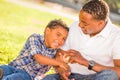 African American Father and Mixed Race Son Playing with Baseball in the Park Royalty Free Stock Photo