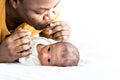 African American father is playing tease with his 12-day-old baby newborn son lying in bed Royalty Free Stock Photo