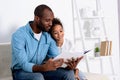 african american father reading book to daughter
