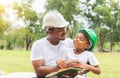 African american father and son in hard hat reading a book, Happy dad and son having a picnic in the park, Happiness family Royalty Free Stock Photo
