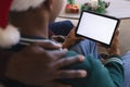 African american father and son having christmas tablet video call, copy space on screen