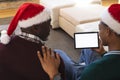 African american father and son having christmas tablet video call, copy space screen
