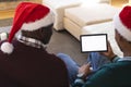 African american father and son having christmas tablet video call, copy space screen