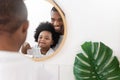 African American Father and Son looking at mirror brushing teeth in bathroom