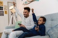 African american father and son making winner gesture while playing game Royalty Free Stock Photo