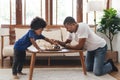 African American Father and son playing chess in living room together. Happy Black Family engaged in board game on holiday Royalty Free Stock Photo