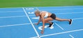 An African American female athlete stands poised at the starting line on the Olympic blue track, embodying the concept of race