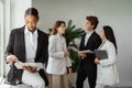 African american female boss using digital tablet, working in office with group of diverse colleagues on the background Royalty Free Stock Photo