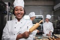 African American female chef looks at camera with a cheerful smile in a kitchen