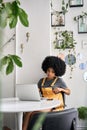 African american female college student in cafe with laptop learning online.