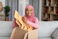 African american female customer unpacking parcel, opening box and rejoicing to new clothes, smiling at camera Royalty Free Stock Photo