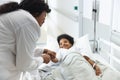 African american female doctor talking to girl patient lying on bed in corridor at hospital Royalty Free Stock Photo