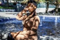 African american  female fashion model with an Afro is sitting in a park by in Chicago. Royalty Free Stock Photo